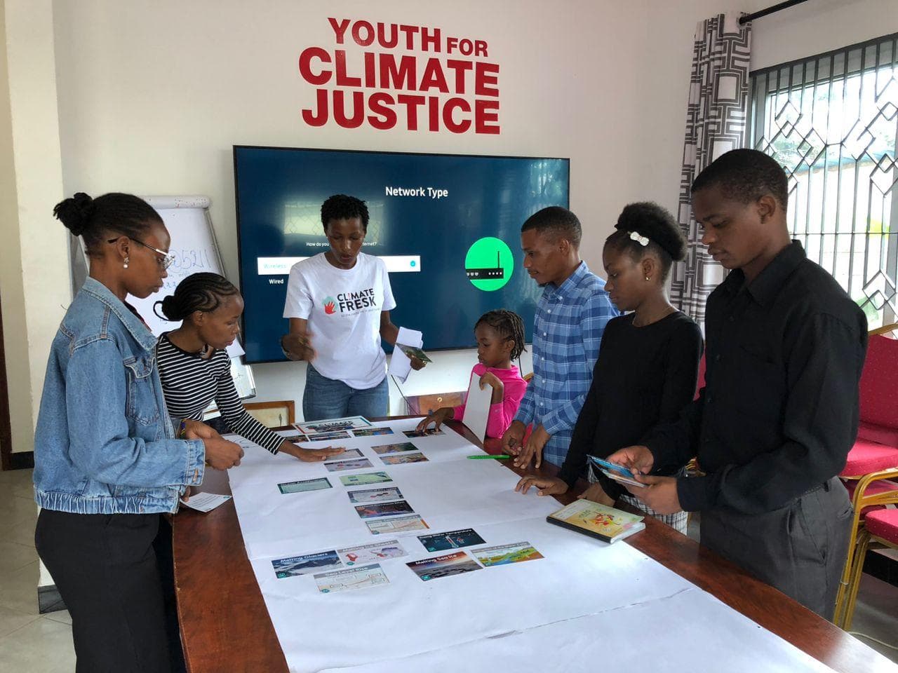 Participants arranging Climate Fresk cards on a table during a group discussion.