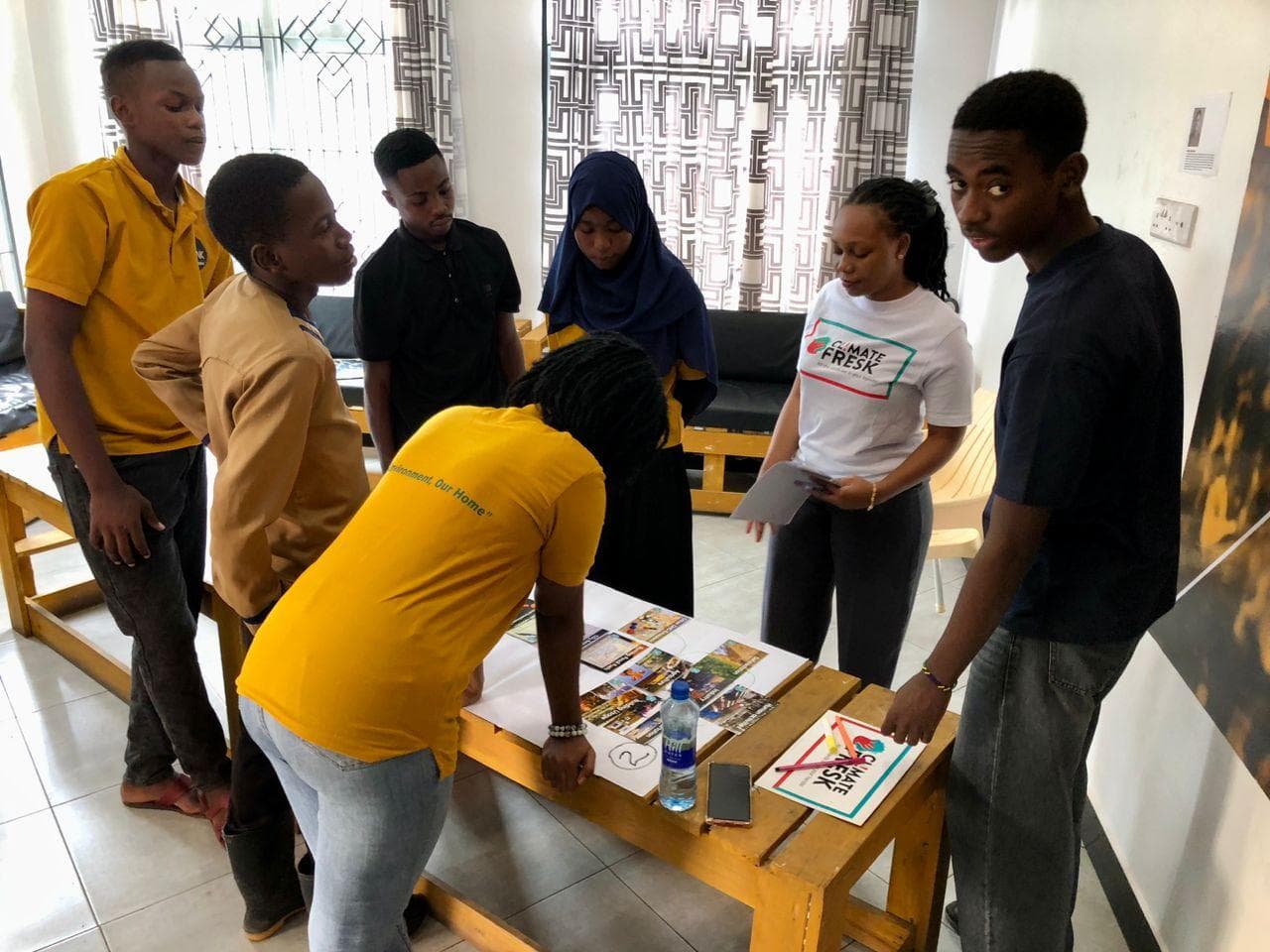 A group discussing cards and climate connections around a workshop table.
