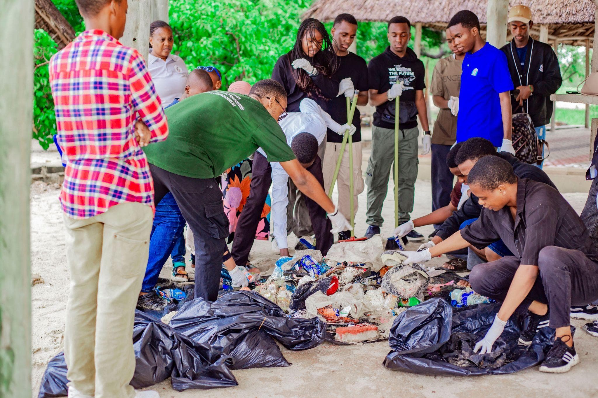 Volunteers sorting beach litter while other participants observe.